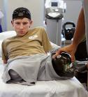 23-year-old Iraq war veteran from New York watches his physical therapist remove his prosthetic legs